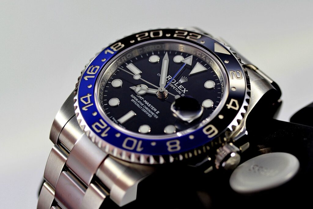 A Rolex GMT Master II watch with a stainless steel case and black dial